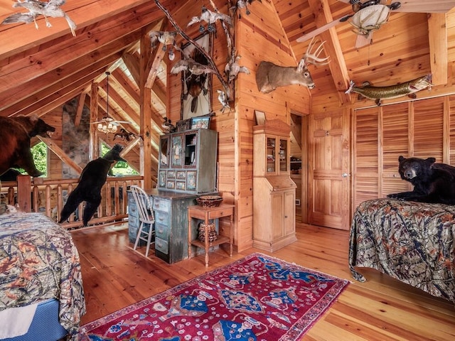 bedroom with vaulted ceiling with beams, wood walls, hardwood / wood-style floors, and wood ceiling