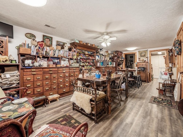 dining area with ceiling fan, hardwood / wood-style floors, and a textured ceiling