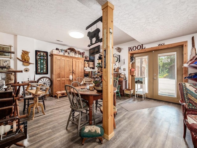 dining room featuring hardwood / wood-style floors, a textured ceiling, and french doors