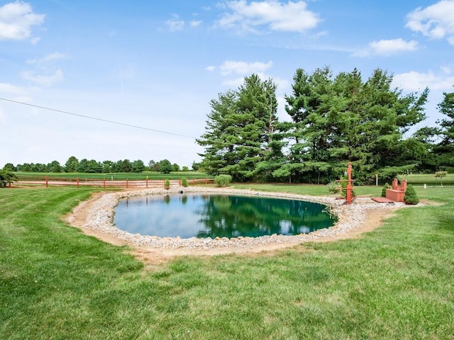 view of swimming pool with a water view and a yard