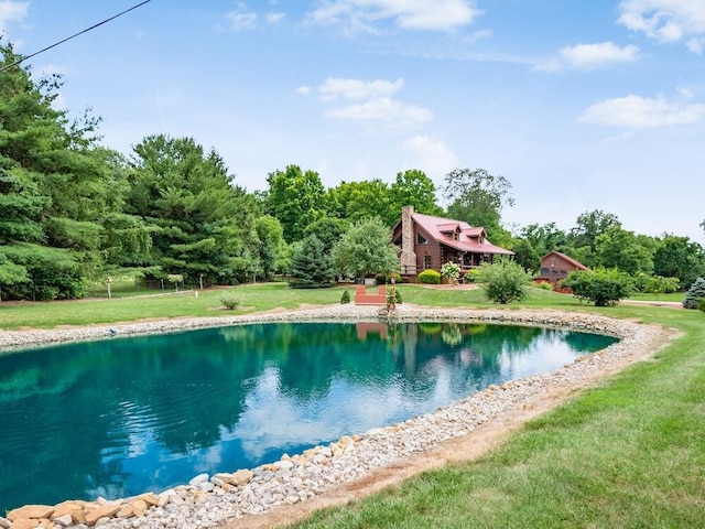 view of pool with a yard and a water view