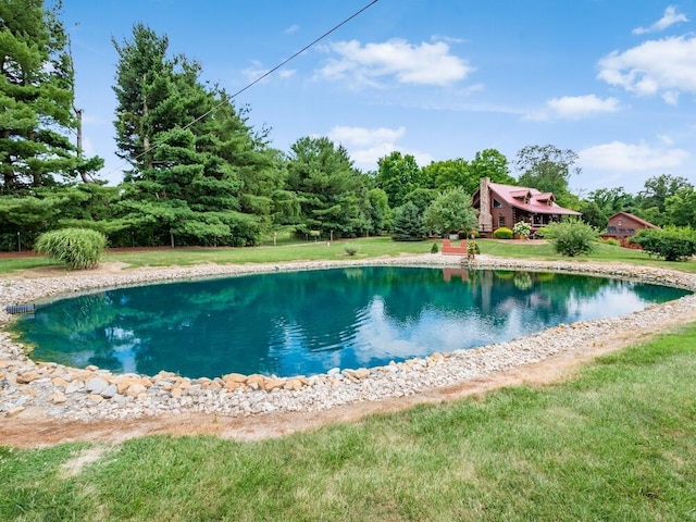 view of pool featuring a lawn