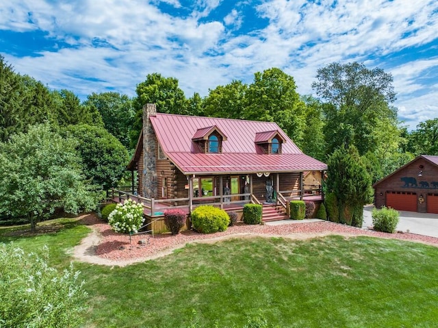 log-style house featuring a garage, covered porch, an outdoor structure, and a front yard