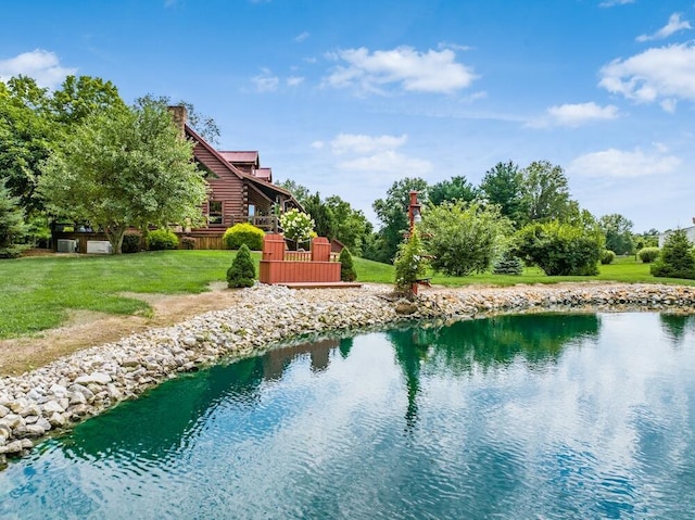 view of swimming pool with a yard and a water view