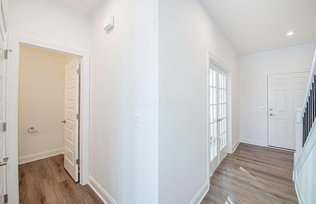 hall with baseboards and light wood finished floors