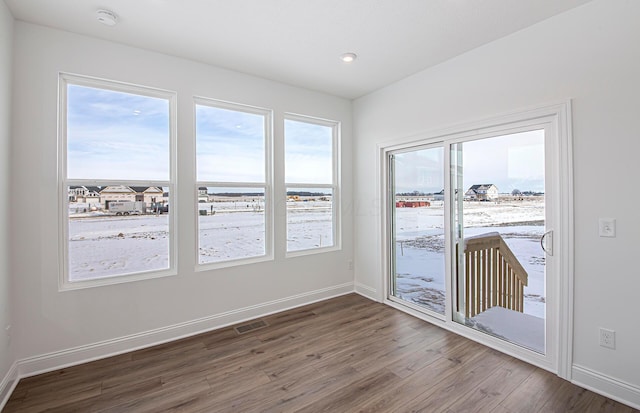 unfurnished room featuring dark wood-style floors, baseboards, and visible vents