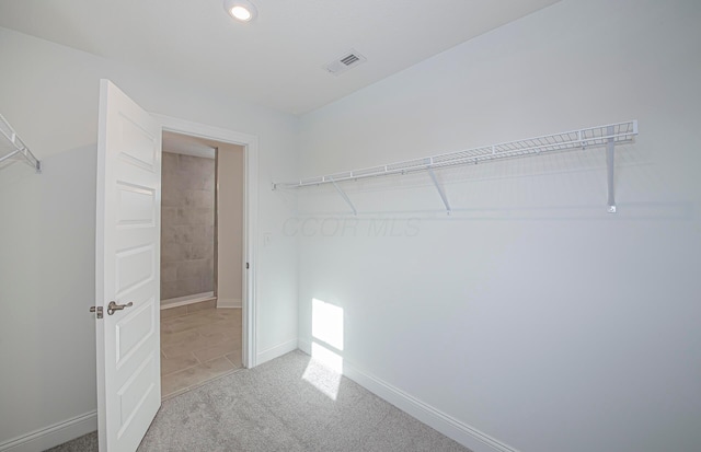 spacious closet with visible vents and carpet