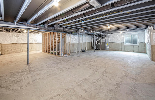 unfinished basement featuring heating unit and electric water heater