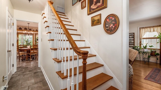 stairway featuring a notable chandelier and hardwood / wood-style flooring