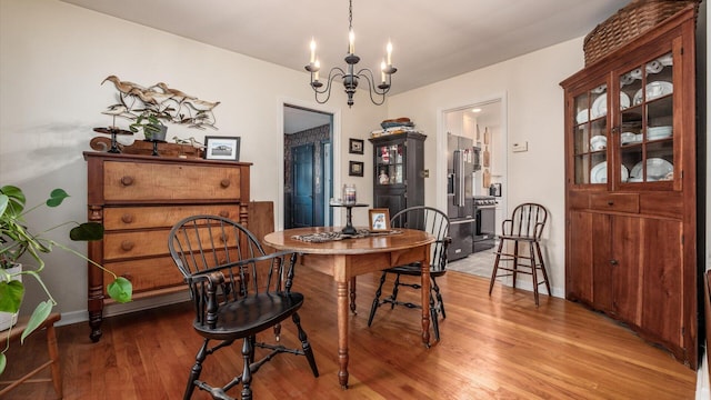 dining space featuring a notable chandelier and light wood-type flooring