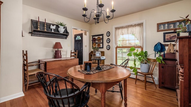 dining space with hardwood / wood-style flooring, baseboard heating, and an inviting chandelier