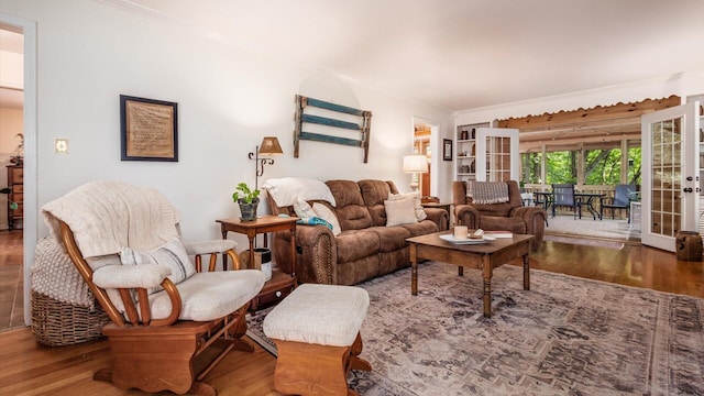 living room featuring french doors, ornamental molding, and wood-type flooring