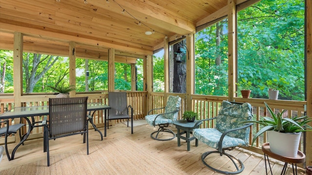 sunroom / solarium featuring beamed ceiling, wood ceiling, and a wealth of natural light