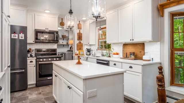 kitchen featuring appliances with stainless steel finishes, separate washer and dryer, a kitchen island, and white cabinetry