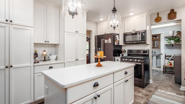 kitchen with white cabinetry, stainless steel appliances, pendant lighting, decorative backsplash, and a kitchen island