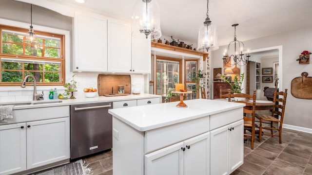 kitchen featuring pendant lighting, dishwasher, backsplash, sink, and white cabinetry