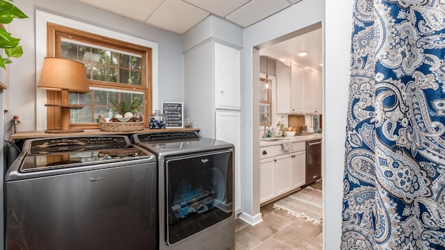 laundry room with washer and dryer, light tile patterned floors, and sink