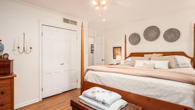 bedroom with light hardwood / wood-style flooring, a closet, and ornamental molding