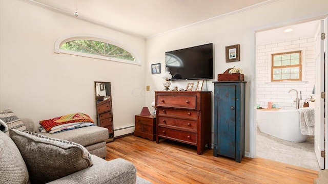 sitting room featuring light wood-type flooring, baseboard heating, and crown molding