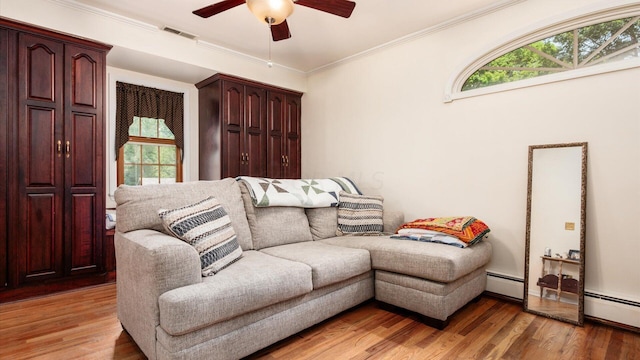 living room featuring ceiling fan, ornamental molding, a baseboard radiator, and hardwood / wood-style flooring