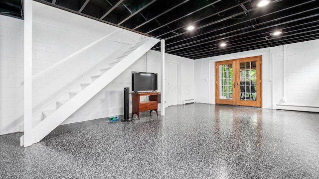 basement featuring french doors and a baseboard radiator