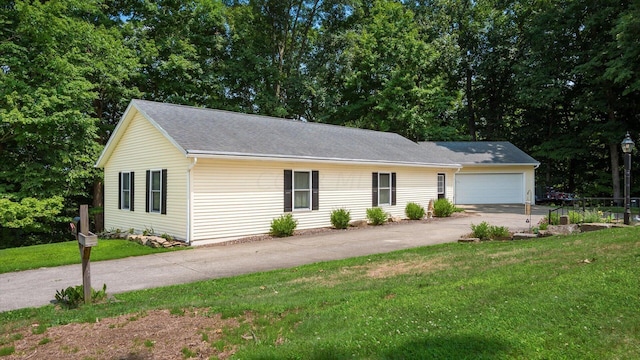 ranch-style house featuring a garage and a front yard