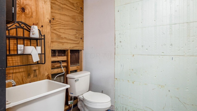 bathroom featuring a tub to relax in, sink, and toilet