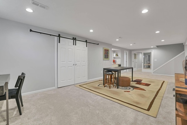 interior space featuring a barn door and light colored carpet