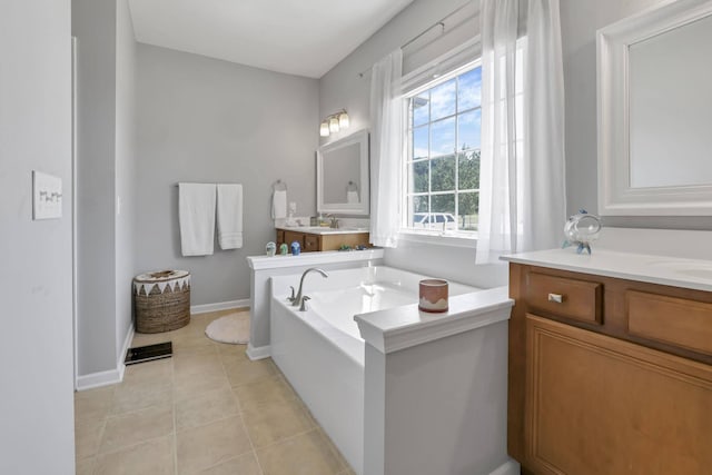 bathroom with a washtub, vanity, and tile patterned floors