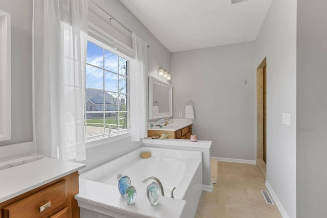 bathroom featuring tile patterned floors, a bath, vanity, and a healthy amount of sunlight