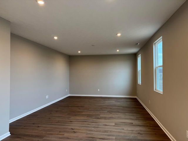 unfurnished room with dark hardwood / wood-style flooring