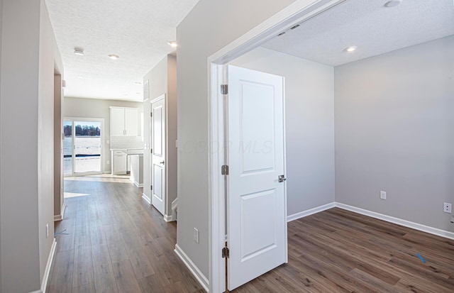 hall with dark hardwood / wood-style flooring and a textured ceiling