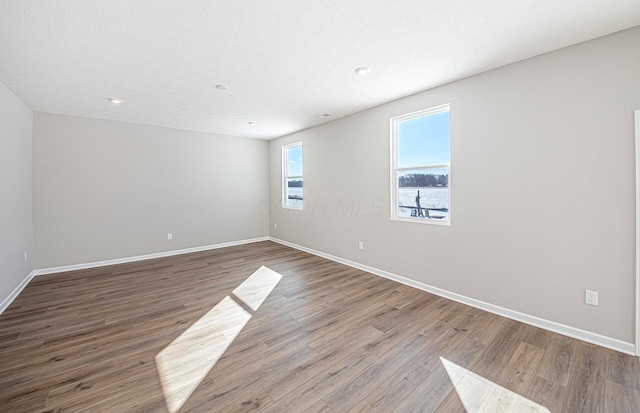 empty room with hardwood / wood-style flooring and a textured ceiling