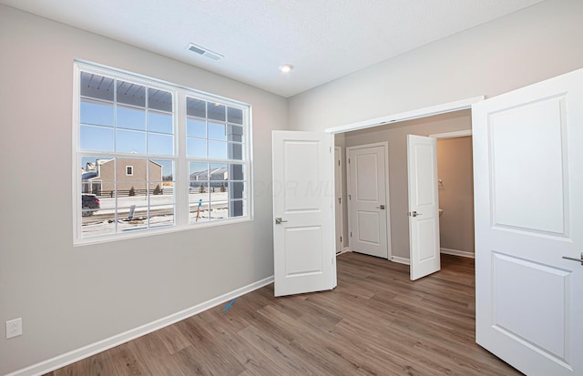 unfurnished bedroom featuring wood-type flooring and a textured ceiling