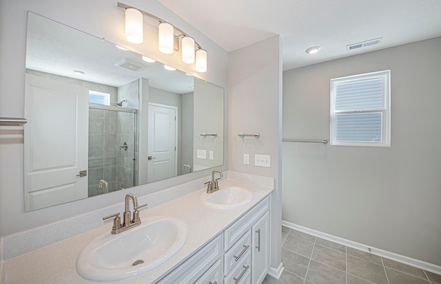 bathroom with vanity, a textured ceiling, tile patterned floors, and walk in shower