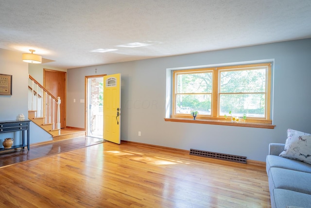 living room with a textured ceiling and light hardwood / wood-style flooring