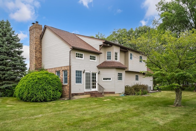 rear view of property featuring a lawn