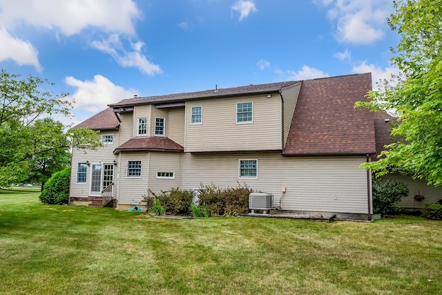 rear view of house with a yard and central air condition unit