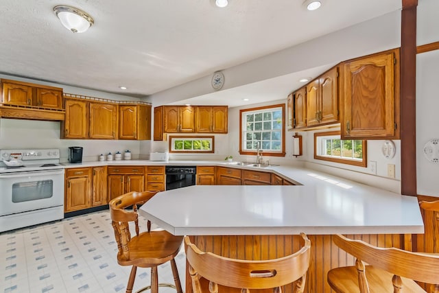 kitchen featuring kitchen peninsula, a kitchen bar, ventilation hood, dishwasher, and white range with electric cooktop