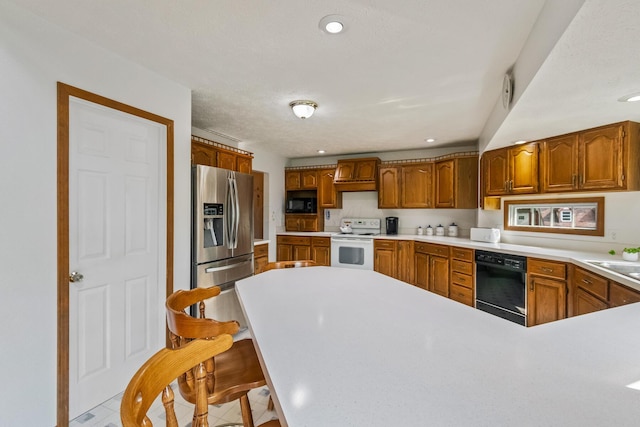 kitchen featuring black appliances, sink, light tile patterned floors, a kitchen bar, and kitchen peninsula