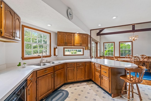 kitchen featuring kitchen peninsula, a breakfast bar, a wealth of natural light, and hanging light fixtures