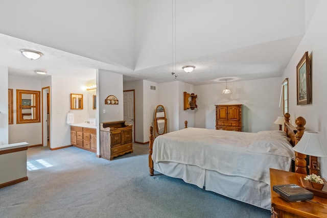 bedroom featuring ensuite bathroom and light colored carpet