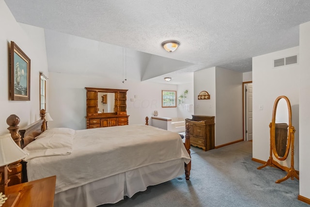 carpeted bedroom with a textured ceiling and vaulted ceiling