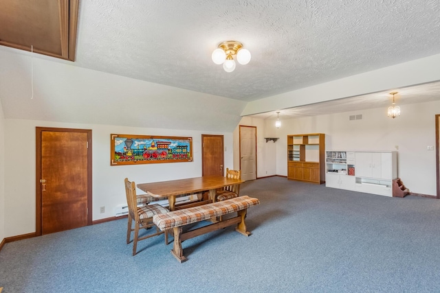 dining room featuring carpet, a textured ceiling, and vaulted ceiling