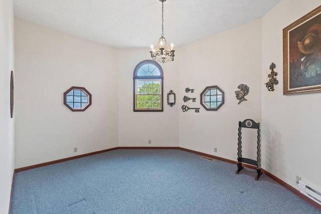 unfurnished room featuring carpet, an inviting chandelier, and a baseboard heating unit