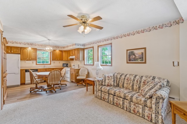 living room with sink, light hardwood / wood-style floors, plenty of natural light, and ceiling fan