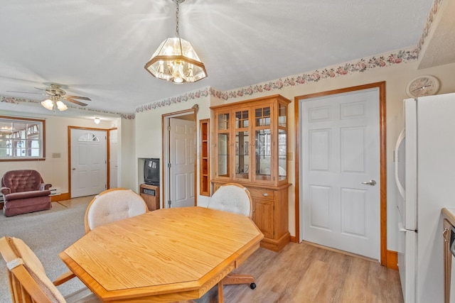 dining area with ceiling fan and light wood-type flooring