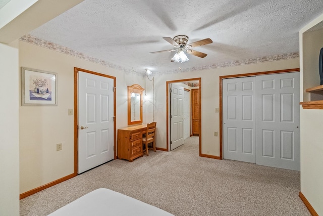 carpeted bedroom featuring a textured ceiling and ceiling fan