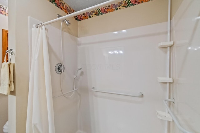 bathroom with a shower with curtain and a textured ceiling