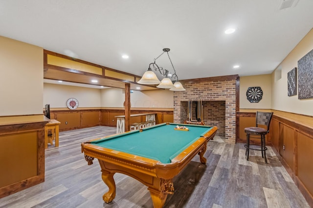 playroom featuring a wood stove, pool table, and light hardwood / wood-style flooring